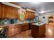 Well-lit kitchen with wood cabinets, a center island, and a view into an open-plan dining area at 1 Gatesway Ct, Durham, NC 27707