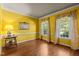 Bright room featuring hardwood floors, yellow walls, and two windows with decorative curtains at 1 Gatesway Ct, Durham, NC 27707