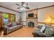 Cozy living room with a brick fireplace, floral sofas, and unique ceiling fan at 1 Gatesway Ct, Durham, NC 27707