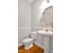 Cozy half bathroom featuring a pedestal sink, an octagon mirror, and wood-look flooring at 100 Highfield Ave, Cary, NC 27519