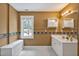 Bright bathroom featuring white cabinets, tiled floors, and a window providing natural light at 100 Highfield Ave, Cary, NC 27519