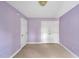 Lilac bedroom with neutral carpet, ceiling fan, and closet at 100 Highfield Ave, Cary, NC 27519
