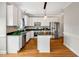 Modern kitchen with white cabinets, stainless steel appliances, granite countertops, and a kitchen island at 100 Highfield Ave, Cary, NC 27519