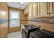 Functional laundry room with washer and dryer, granite countertop, and overhead cabinets at 100 Highfield Ave, Cary, NC 27519