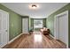 Green living room with a sofa, natural light from the window, and two entry doors at 100 Highfield Ave, Cary, NC 27519