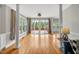 Open living room featuring hardwood floors, large windows, columns, and access to the outdoor deck at 100 Highfield Ave, Cary, NC 27519