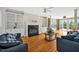 Spacious living room with hardwood floors, built-in bookshelves, a fireplace, and access to the outdoor deck at 100 Highfield Ave, Cary, NC 27519