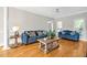 Inviting living room with hardwood floors, neutral walls, and comfortable blue sofas with decorative pillows at 100 Highfield Ave, Cary, NC 27519