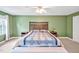 Spacious main bedroom with an olive accent wall, ceiling fan, and large bed with two side tables at 100 Highfield Ave, Cary, NC 27519