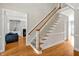 Elegant staircase with wood railing, carpeted steps, and hardwood flooring at 100 Highfield Ave, Cary, NC 27519
