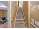 Carpeted stairway with a wood handrail leading to an upper floor, with access to a workout area at 100 Highfield Ave, Cary, NC 27519