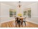 Bright dining room with natural light, modern chandelier, and beautiful wood laminate flooring at 101 Abram Way, Clayton, NC 27520