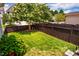 Lush backyard featuring a well-maintained lawn, privacy fence, and mature landscaping and trees at 104 Treywood Ln, Chapel Hill, NC 27516