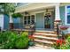 Inviting front porch with stone accents, a ceiling fan, decorative flowerpots, and a cozy seating area at 104 Treywood Ln, Chapel Hill, NC 27516