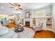 Bright living area with fireplace, built-ins, and hardwood floors, seamlessly connected to the kitchen at 104 Treywood Ln, Chapel Hill, NC 27516