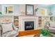 Living room fireplace with white tile and built-in shelving and hardwood floors at 104 Treywood Ln, Chapel Hill, NC 27516