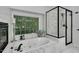 Bright bathroom featuring a jacuzzi tub, glass shower, and natural light from the window at 105 Walter Hagen Dr, Mebane, NC 27302
