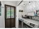 Well-organized laundry room featuring modern washer and dryer, geometric wallpaper, and stylish lighting fixtures at 105 Walter Hagen Dr, Mebane, NC 27302