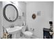 Cozy powder room featuring a pedestal sink, toilet, and decorative wall art at 105 Walter Hagen Dr, Mebane, NC 27302