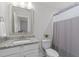 Neutral bathroom with a gray granite vanity, a square framed mirror, and a shower curtain with gray accents at 1108 Lowland St, Apex, NC 27523