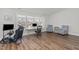 Bright bedroom featuring hardwood floors, neutral paint, a large window, and two comfortable arm chairs at 1108 Lowland St, Apex, NC 27523