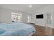 Bright bedroom featuring hardwood floors, a large window, and access to an ensuite bathroom at 1108 Lowland St, Apex, NC 27523