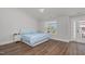 Bright bedroom featuring hardwood floors, a large window, and access to a private balcony at 1108 Lowland St, Apex, NC 27523