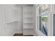Walk-in closet with built-in shelving and wooden rods, lit by a bright window at 1108 Lowland St, Apex, NC 27523