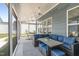 Spacious screened porch with a wicker sectional, ceiling fan, and view to a comfortable hammock at 1108 Lowland St, Apex, NC 27523