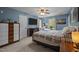 Comfortable bedroom with cool blue walls, ceiling fan, guitars, and a large-screen TV at 112 Autumn Ridge Dr, Knightdale, NC 27545