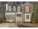 Charming two-story home featuring a mix of brick and siding, dormer windows, and a welcoming yellow front door at 112 Solstice Cir, Cary, NC 27513