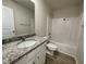 Bathroom featuring a granite countertop vanity, framed mirror, and a shower-tub combo at 116 Oakfield Trace Dr, Four Oaks, NC 27524