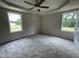 Spacious bedroom with a ceiling fan, carpeted floor and natural light streaming in from two windows at 116 Oakfield Trace Dr, Four Oaks, NC 27524