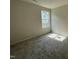 Cozy bedroom featuring plush carpeting, a neutral color palette, and a window for ample natural light at 116 Oakfield Trace Dr, Four Oaks, NC 27524