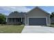 Charming single-story home featuring a covered front porch, attached two-car garage and newly paved driveway at 116 Oakfield Trace Dr, Four Oaks, NC 27524