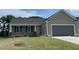 Charming single-story home featuring a covered front porch, attached two-car garage and well-manicured lawn at 116 Oakfield Trace Dr, Four Oaks, NC 27524