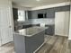 Modern kitchen featuring gray cabinets, granite countertops, stainless appliances and a functional island at 116 Oakfield Trace Dr, Four Oaks, NC 27524