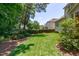 Well-maintained backyard featuring lush lawn, mature trees, and privacy hedge at 117 Drakewood Pl, Cary, NC 27518