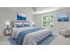 Bright bedroom features a ceiling fan, large window and is staged with blue accents at 117 Drakewood Pl, Cary, NC 27518
