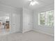 Neutrally decorated bedroom with a large window, plush carpeting, and two closets at 117 Drakewood Pl, Cary, NC 27518