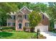 Charming two-story brick home with manicured lawn and blue shutters with attached two car garage at 117 Drakewood Pl, Cary, NC 27518