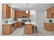 Bright kitchen featuring white countertops, tile backsplash, stainless steel appliances, and wood cabinets at 117 Drakewood Pl, Cary, NC 27518