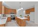 Well-lit kitchen featuring wooden cabinets, stainless steel appliances, and a spacious island with a white countertop at 117 Drakewood Pl, Cary, NC 27518
