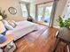 Light-filled bedroom with wood floors, neutral rug, and access to outdoor balcony at 118 Chestnut St, Durham, NC 27707