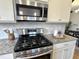 Updated kitchen features stainless steel appliances, and granite counters and opens to the dining area at 118 Chestnut St, Durham, NC 27707