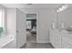 Bright bathroom showcasing tub, double vanity, decorative mirrors, sleek fixtures, wood look floors, and neutral color palette at 1214 Valley Dale Dr, Fuquay Varina, NC 27526