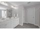 Bright bathroom with double sink vanity, decorative mirrors, sleek fixtures, wood look floors, and walk-in shower at 1214 Valley Dale Dr, Fuquay Varina, NC 27526