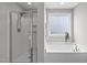 Bright bathroom featuring a glass enclosed shower, soaking tub, window, and sleek fixtures at 1214 Valley Dale Dr, Fuquay Varina, NC 27526