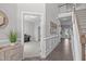 Hallway featuring wood floors, white wainscoting, and a view into the adjacent room at 1214 Valley Dale Dr, Fuquay Varina, NC 27526