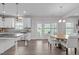 Bright eat-in kitchen features white cabinets, stainless appliances, gray backsplash and a center island with granite countertop at 1214 Valley Dale Dr, Fuquay Varina, NC 27526